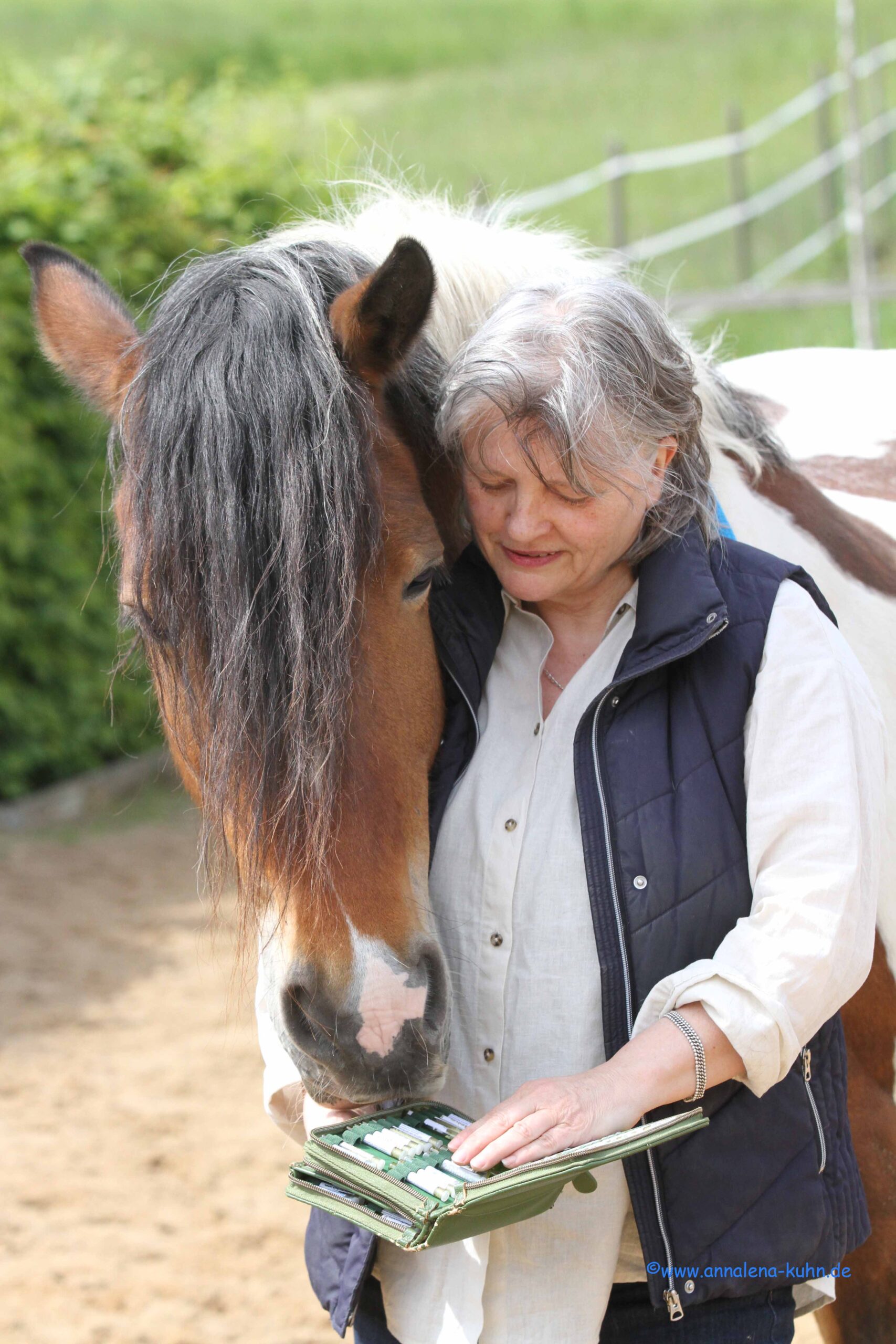 Peggy Schmah und ein geschecktes pferd, das über die Schulter blickt